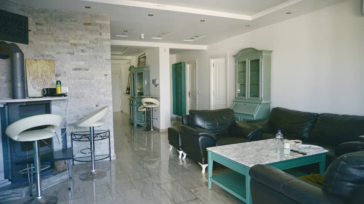 Salon en cuir, cheminée et mur en pierre