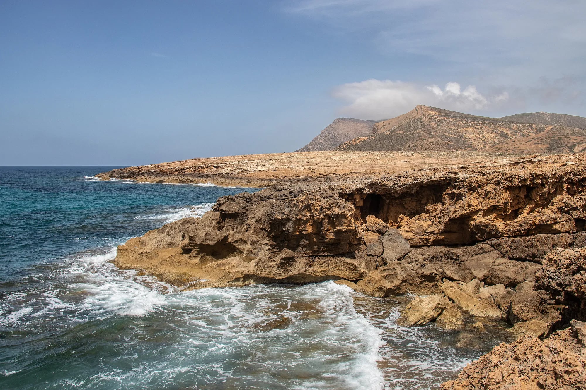 Sandsteinfelsen und der Djebel über dem Meer